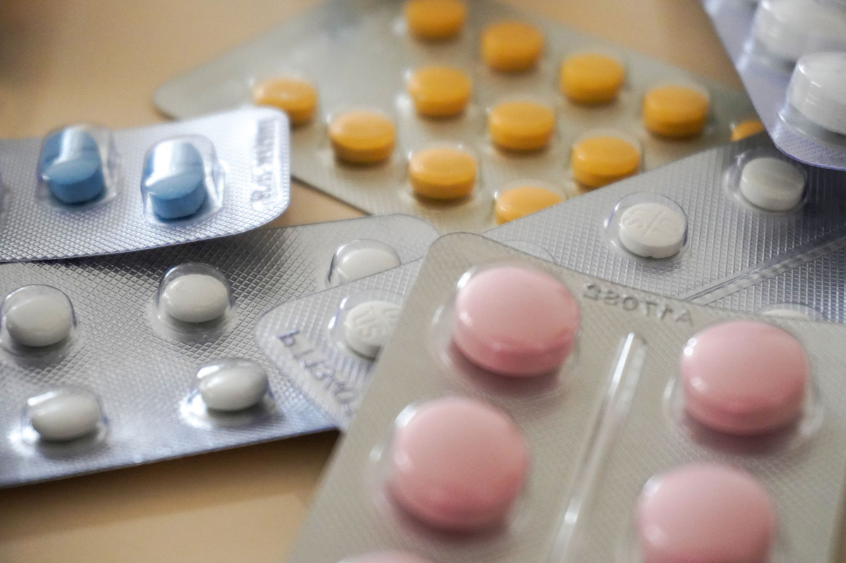 Close-up view of assorted colorful medication blister packs with diverse pills.