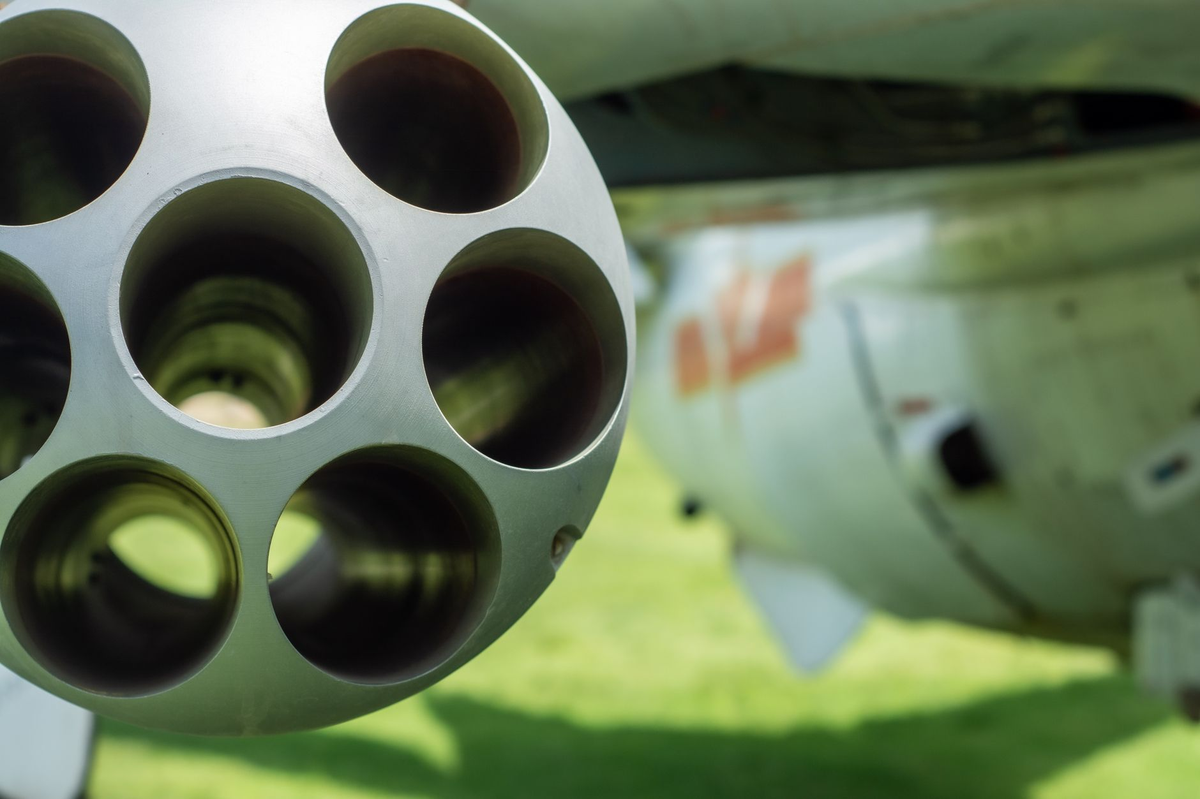Detailed close-up of an aircraft's gun barrel with blurred background.